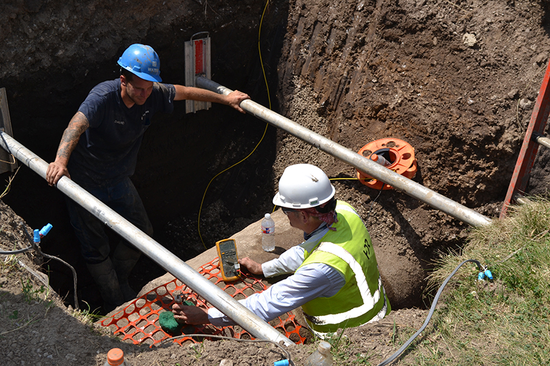Two water employees working on a pipe